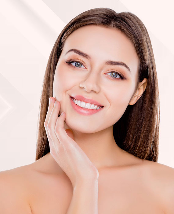 Young brunette woman smiling and touching her face | Fillers | Elevate Medical Aesthetics