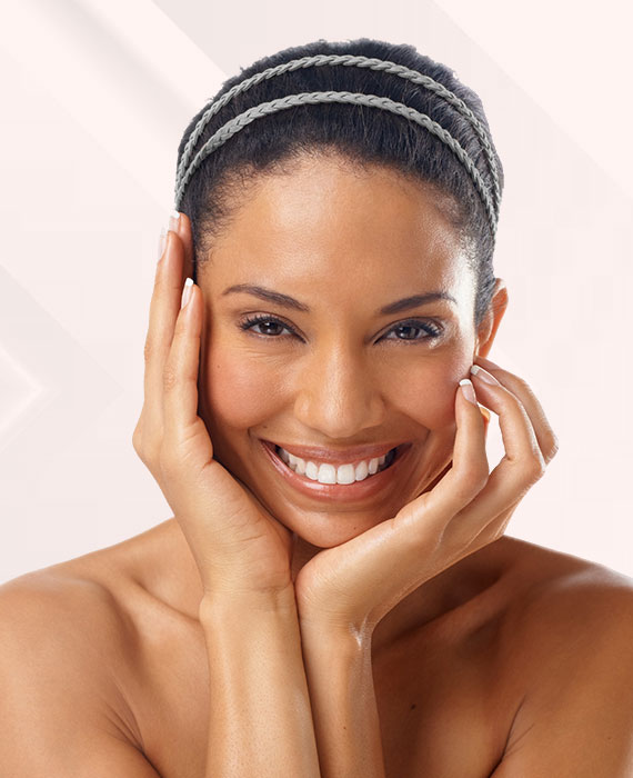 Beautiful African American woman smiling and touching her smooth face | Skin Rejuvenation | Elevate Medical Aesthetics